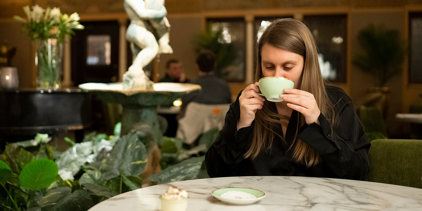 Kvinne som drikker kakako på Hotel Bristol