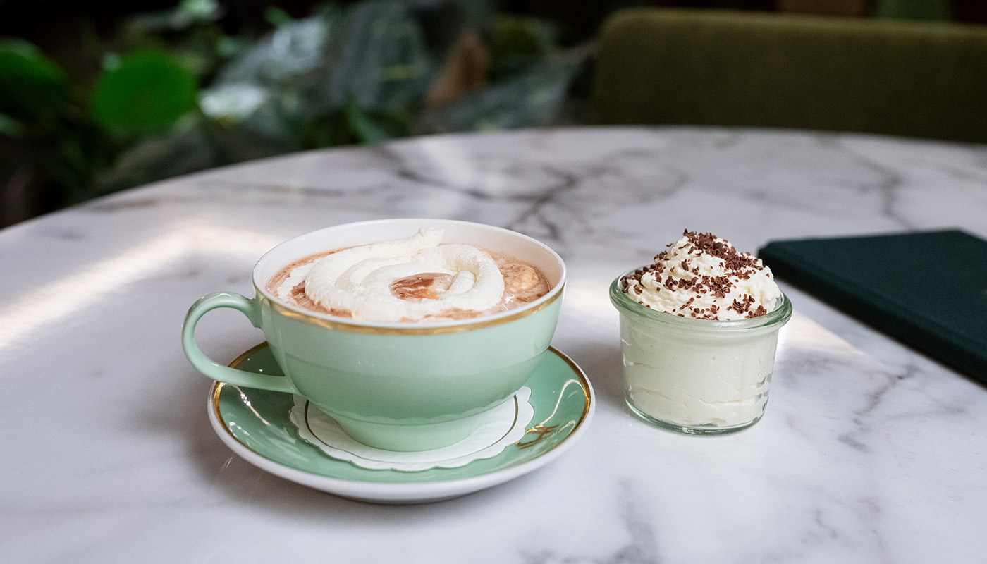 Nærbilde av kopp med kakao og krem.