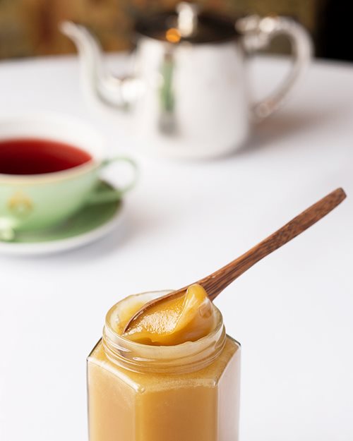 Nærbilde av tekopp med honning i front