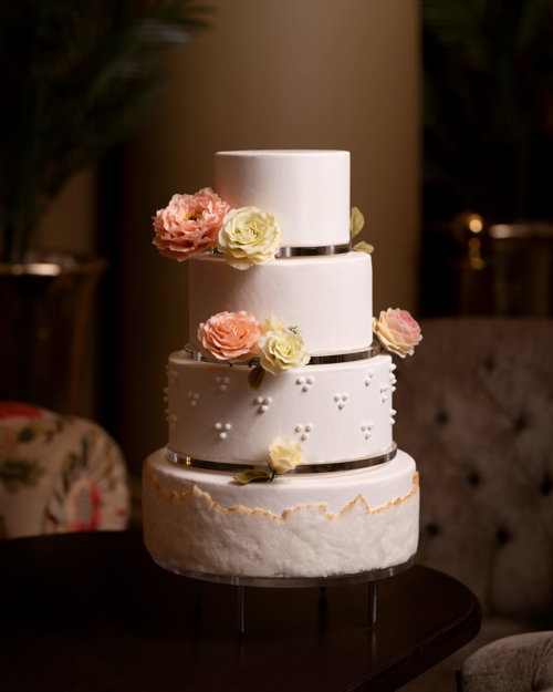 Rosa bryllupskake med 4 etasjer, pyntet med rosa og hvite roser.