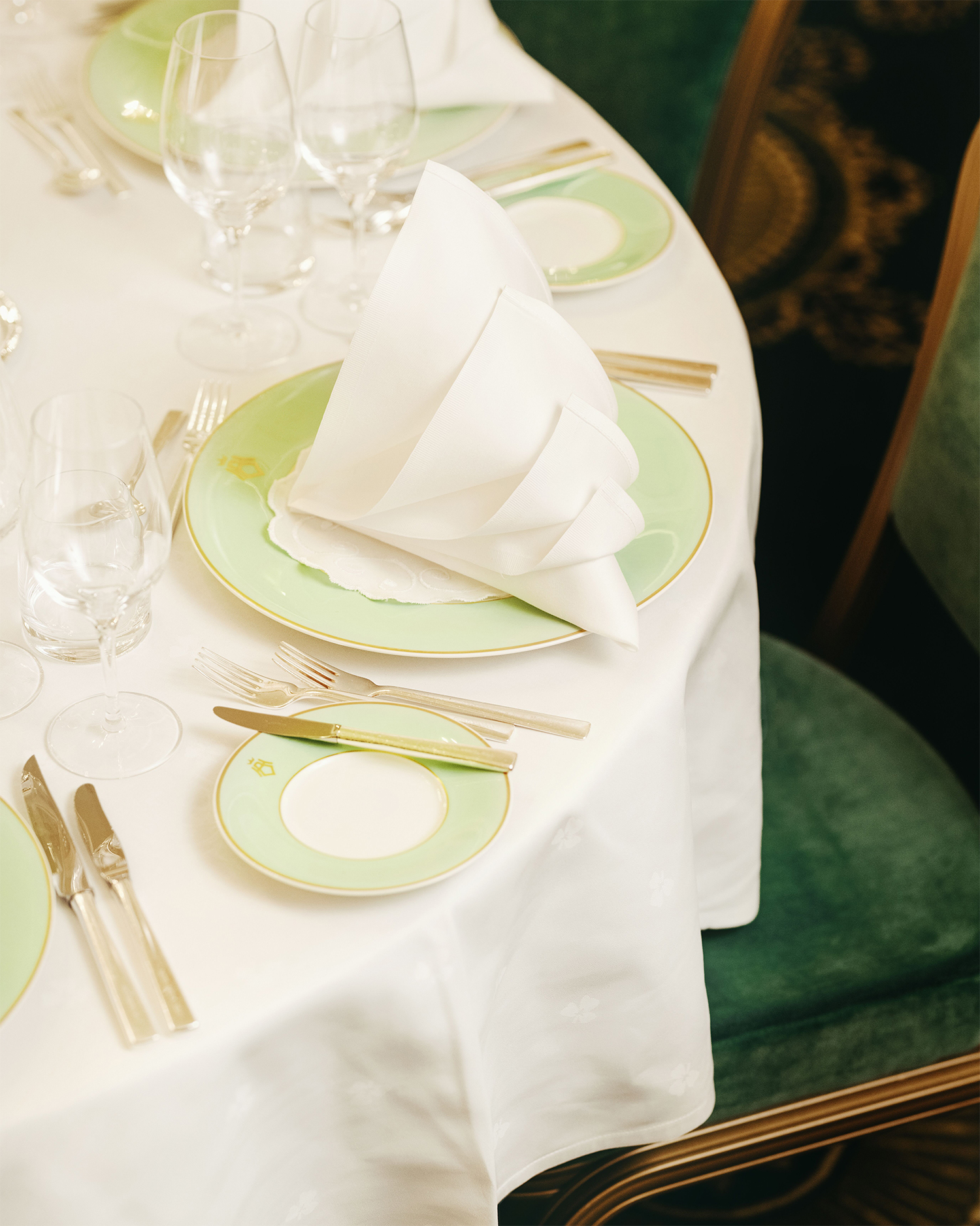 Nærbilde av oppdekket bord med hvite duker, sølvbestikk og brettet serviett