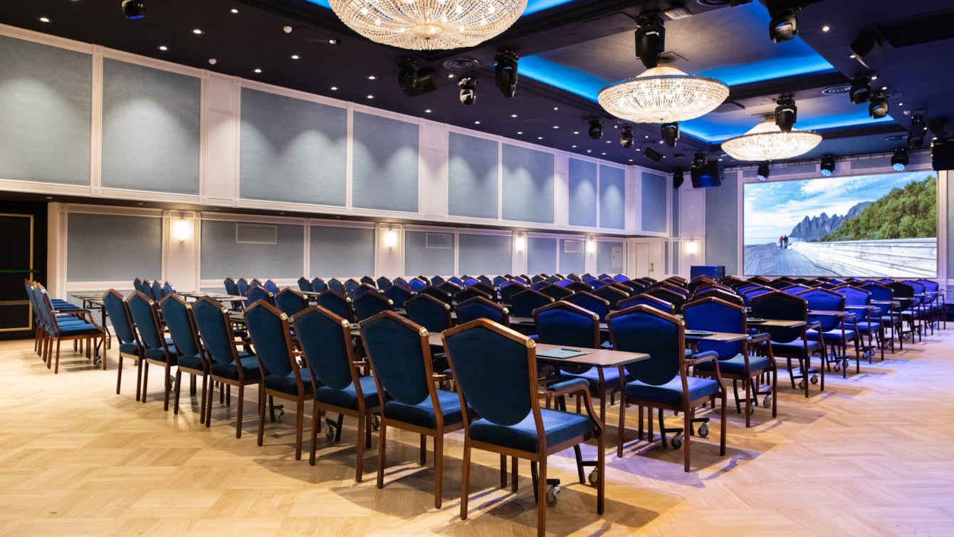 Cinema setup in spacious Maud conference area. Dark blue chairs, and counters. 