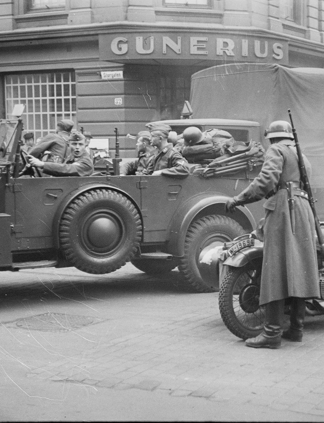 Svart-hvitt bilde av en bil med tyske soldater utenfor Gunerius i Oslo under krigen