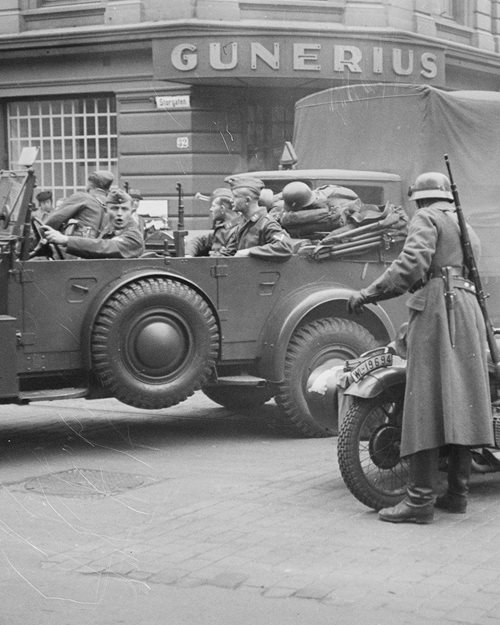 Svart-hvitt bilde av en bil med tyske soldater utenfor Gunerius i Oslo under krigen