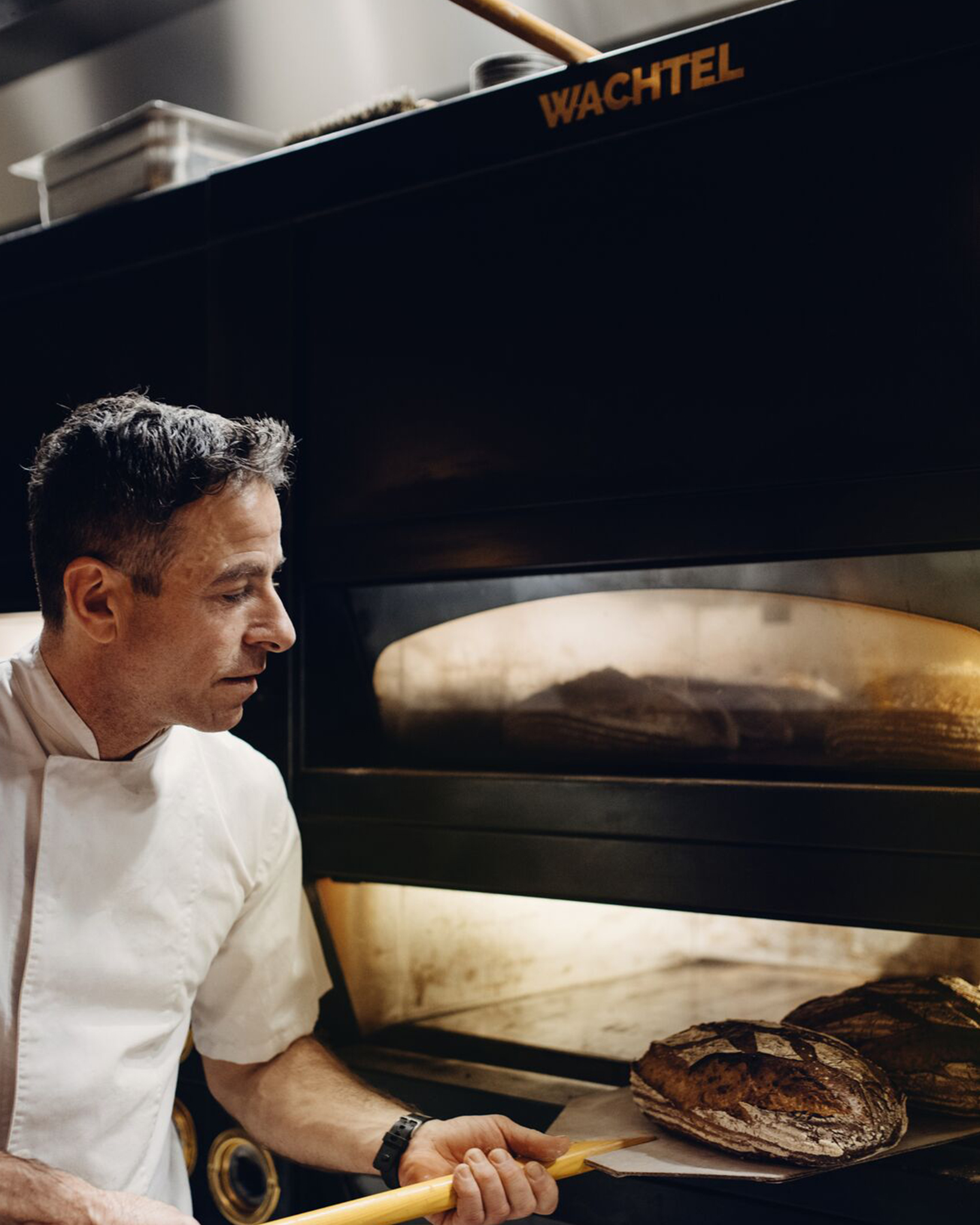 Baker på Hotel Bristol tar brød ut av ovnen