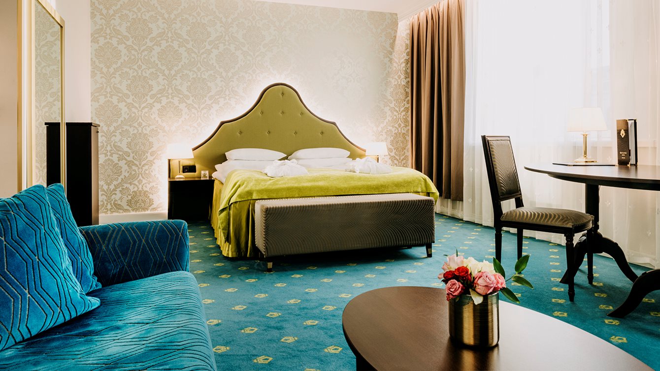 Dobbeltseng og nattbord i superior room på Hotel Bristol i Oslo