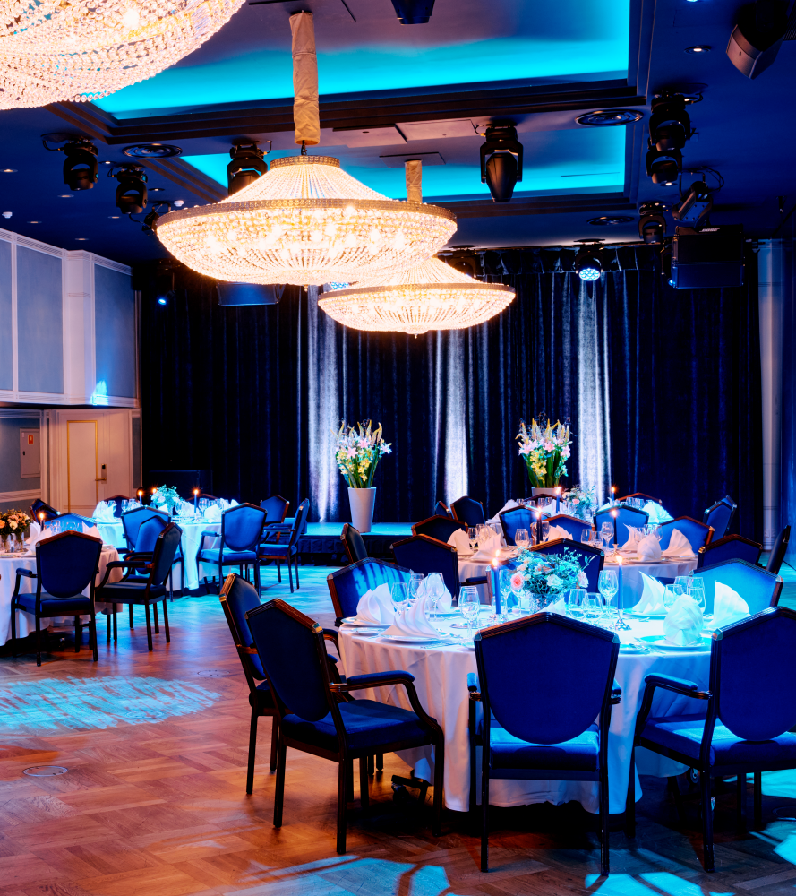 Nærbilde av oppdekket bord i Haakonsalen med brettede servietter og blomster på bordet