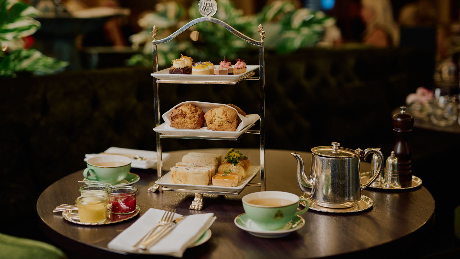 Rudt, mørkt bord dekket til high tea.