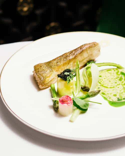Hvit fisk med grønnsakstilbehør servert på Bristol Grill