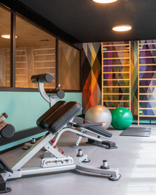 Treningsrom med ribbevegg, gymballer, yogamatter og treningsapparater.